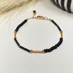 The combination of black and gold adds an understated touch luxury to your wrist. This bracelet consist of a mix of matte black beads  surrounding some pops of gold. Wear alone or stack it! - 3mm width - Adjustable - 6 inches plus 1.5 inch gold filled extender chain * Each order will come with an eco-friendly branded cloth pouch or black kraft box. I try to consolidate orders with multiple items into one bag or box to reduce landfill waste.  However, please let me know if the jewelry is for a gift so they can be packaged accordingly.  All ordered will be packed with reused/ recycled materials.  *Please see shop announcement section for care instructions. Minimalist Black Matte Finish Jewelry, Adjustable Black Bracelets With Gold Beads, Trendy Black Beaded Bracelets With Tiny Beads, Minimalist Black Beaded Bracelets, Minimalist Black Jewelry With Gold Beads, Adjustable Matte Gold Minimalist Bracelet, Minimalist Black Beaded Bracelets For Everyday, Black Minimalist Bracelets For Everyday Wear, Minimalist Black Bracelets For Everyday