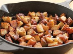 a pan filled with cooked potatoes on top of a wooden table