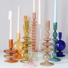 there are many different colored candles on the table