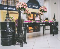 the eiffel tower is decorated with pink flowers and black barrels for desserts