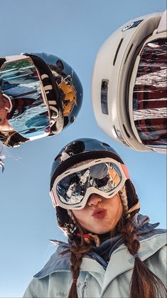 a woman wearing ski goggles standing next to another person