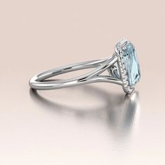 an oval cut aqua blue topaze ring with diamonds on the band and shoulders