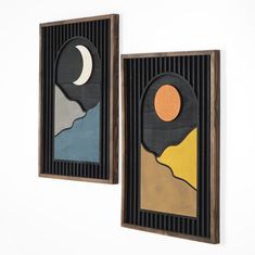 two framed art pieces with mountains and moon on them, one is brown the other is blue