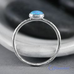 This Sterling Silver Blue Opal Ring features an 8 mm x 6 mm oval lab grown Blue Opal cabochon that has been securely set in a highly polished fine silver bezel. The band is made of a sturdy round Sterling Silver wire that has a hammered texture around the entire band. These beautiful rings make unique promise rings, lovely stacking rings, great birthstone rings, or just a wonderful love tokens for yourself or your special someone. This man-made Blue Opal is created from very uniform nanoparticle Oval Promise Ring, Opal Ring Silver, Opal Promise Ring, Unique Promise Rings, Blue Opal Ring, October Birthstone Rings, Ring Blue, Onyx Ring, Pinky Ring