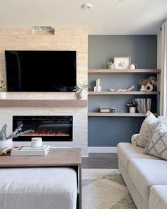 a living room with a couch, coffee table and television mounted on the wall above it