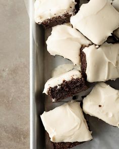 a pan filled with brownies covered in white frosting