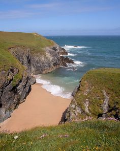 the beach is next to some cliffs by the ocean