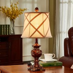 a lamp sitting on top of a wooden table next to a brown leather chair in a living room