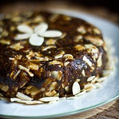 a cake on a plate with almonds and nuts