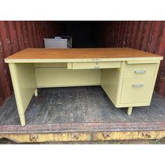 an old yellow desk sitting on top of a wooden floor