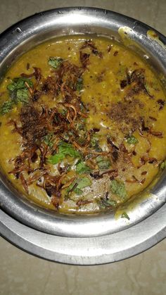 a metal bowl filled with food on top of a table