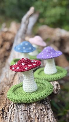 small crocheted mushrooms sitting on top of a log