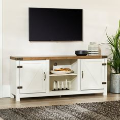 a flat screen tv mounted to the side of a white cabinet in a living room