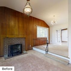 an empty living room with wood paneling and a fireplace