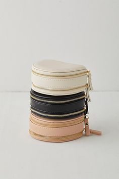 a stack of four different colored and black and white hats with zippers on them