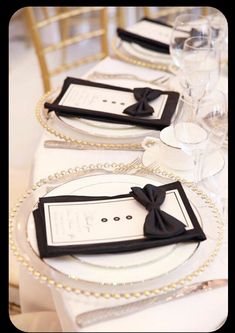 the table is set with white and black place settings