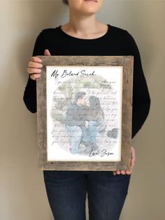 a woman holding up a framed photo with the words, my best dad on it