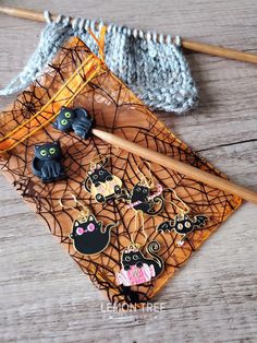 halloween decorations are sitting on top of a wooden table with yarn and knitting needles next to them