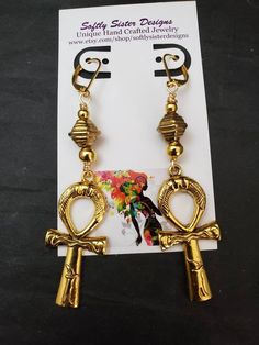 "Beautiful handmade earrings made with high quality gold plated metal Ankh symbol, and nickel free gold plated leverback earwires. Lightweight and easy to wear, these earrings are 3\" long. Please come back and visit to check for more unique new designs and styles For more styles visit my Etsy shop:www.etsy.com/shop/SoftlySisterDesigns" Gold Ankh Shaped Metal Jewelry, Spiritual Gold Hoop Earrings Gift, Gold Ankh Metal Jewelry, Adjustable Gold Plug Earrings With Ear Wire, Gold Symbolic Dangle Jewelry, Symbolic Gold Dangle Jewelry, Gold Brass Clip-on Earrings With Ear Wire, Gold Hoop Earrings With Pierced Copper, Gold Brass Ankh Jewelry