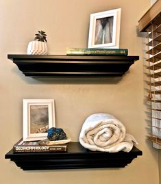 two black shelves with pictures and towels on them