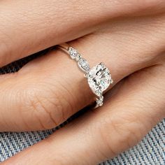 a woman's hand with a diamond ring on top of her finger and an engagement band