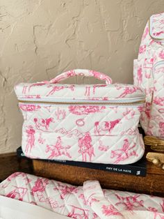 a pink and white bag sitting on top of a wooden table next to other items