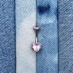 a pair of blue jeans with a pink heart belly ring