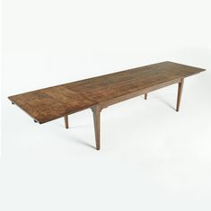 a long wooden table sitting on top of a white floor