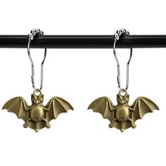 two gold bats hanging from hooks on a black rod with silver balls and metal earwires