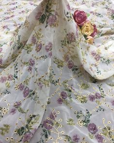 a white and purple flowered fabric with gold trimmings on the bottom half