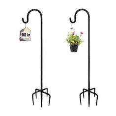 two black metal plant stands with flowers in them and a birdhouse hanging from the top