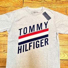 Tommy Hilfiger Grey Tee Size Youth Xl Fits Like A Junior Medium Grey With Blue Tommy Hilfiger Logo Emblazoned Goes Great With Matching Trackpants/Sweatpants And Hoodie Bundle! New With Tags Trendy Gray Tops With Logo Print, Gray Logo Print T-shirt For Spring, Gray Logo Print Casual Shirt, Gray Casual Shirt With Logo Print, Casual Gray Shirt With Logo Print, Sweatpants And Hoodie, Tommy Hilfiger Logo, Tommy Hilfiger Tops, Grey Tee