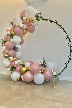 a balloon arch with pink, white and gold balloons in the shape of a crescent