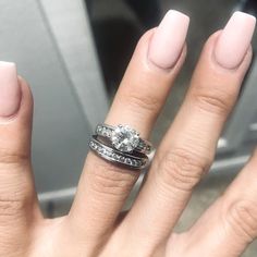 a woman's hand with two wedding rings on her fingers and the other half of her finger