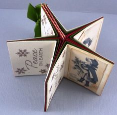 an origami christmas card holder with a star decoration on the front and side