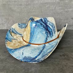 "Summer straw cowboy hat painted in Dallas, TX by a local artist. Glam gold paint and color marbled on a straw cowgirl hat with chin strap, topped with a double tan faux suede cord tied with a nautical knot. The cord is unattached so is easy to replace with your own strap.  This southern beachy sun hat has a modern bohemian look that is perfect for a western glam look, tropical resort casual, or city summer. How It's Made These hats are painted using a method called Hydro-Dipping. Each hat is in Multicolor Curved Brim Sun Hat For Rodeo, Blue Brimmed Straw Hat For Rodeo, Blue Western Straw Hat For Summer, Blue Western Straw Hat With Curved Brim, Western Blue Straw Hat For Summer, Blue Wide Brim Straw Hat For Rodeo, Western Style Blue Straw Hat For Summer, Artisan Straw Hat For Ranch In Summer, Blue Western Hat For Vacation