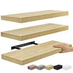 a hand is holding the edge of a shelf with several different colors and sizes on it