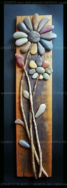 a wooden plaque with stones and leaves on it