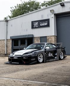 a black sports car parked in front of a building