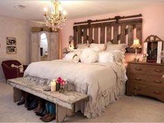 a bedroom with a bed, dresser and chandelier