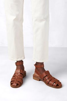 Featuring an open cage-like design and brown leather finish, the Perry fisherman sandals offer an enclosed yet breathable silhouette, so walking in the heat isn’t a deal breaker. They’re complete with a thick strap that wraps around the ankle and fastens with a gold buckle. Upper, Lining, Insole: 100% Cow Leather Outsole: 100% Cuerolite Hardware : 100% Zamak Ecologic Finishing Lining, Insole: 100% Goat Leather Outsole: 100% Cuerolite Hardware : 100% Zamak Ecologic Finishing Ethically Made in Por Fisherman Sandals, Tan Woman, Leather Finish, Goat Leather, Wrap Around, Cow Leather, The Heat, Brown Leather, Cow