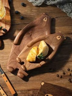 a wooden cutting board topped with slices of pineapple next to knifes and other kitchen utensils