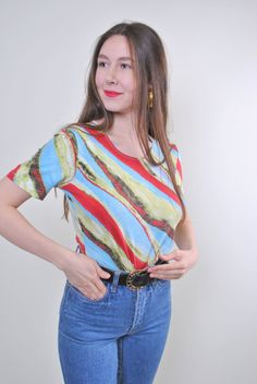 "Abstract print women holiday multicolor tshirt for festival, Size M Welcome to TARASCOMMON.ETSY.COM Unique clothing from the 20th century. Model tall - 170cm M. Sleeve - 8cm / 3.14inch; ( armpit to end of sleeve); Width - 40cm / 15.74inch; Length - 55cm / 21.65inch. All measurements are taken seam to seam while lying flat. Viscose. This item is vintage, so it can have some defects. Additional photos can be send We are glad that you are interested in lots that we sell. Wish you a good shopping! Retro Green Printed T-shirt, Retro Fitted Printed T-shirt, Vintage Short Sleeve Top With All Over Print, Vintage Cotton T-shirt With All Over Print, Retro Blue Printed T-shirt, Vintage Summer Tops With All Over Print, Fitted T-shirt With Vintage Print And Short Sleeves, Multicolor Retro Print Short Sleeve Top, Retro Short Sleeve Top With Vibrant Print