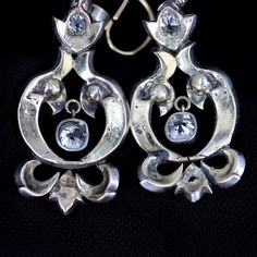 "Georgian silver topped 14k gold drop earrings with over 5 carats of diamonds feature a combination of old mine cut and rose cuts. The stunning earrings have been preserved for nearly 200 years. One has been repaired at some point in its history of ownership. The bottom flourish was reattached and the top of the pendulous was reinforced and reattached. See detailed imagery of repairs. These have not been cleaned by us in case of foil backings on non open backed stone mountings, which were preval Victorian Style Hallmarked Earrings For Formal Occasions, Formal Victorian Hallmarked Earrings, Formal Rose Cut Diamond Chandelier Earrings, Formal Chandelier Earrings With Rose Cut Diamonds, Victorian Chandelier Earrings For Formal Occasions, Single Cut Diamond Drop Earrings For Evening, Vintage Rose Cut Diamond Earrings For Formal Occasions, Victorian Earrings For Evening, Ornate Chandelier Earrings For Formal Events