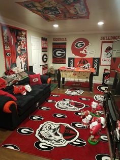 a living room filled with black couches and red rugs