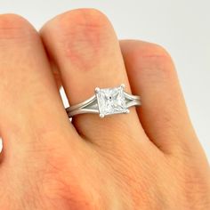 a woman's hand with a white diamond ring on her left and right hand