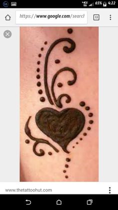 a heart tattoo on the back of a woman's stomach, with swirls and dots