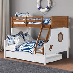 a bunk bed with blue and white striped bedspreads on it, next to a window