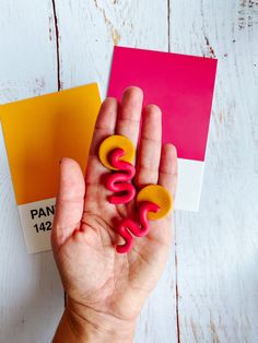 a person's hand holding some type of magnets on top of a table