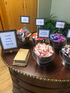 a table topped with lots of different types of candies and signs on top of it